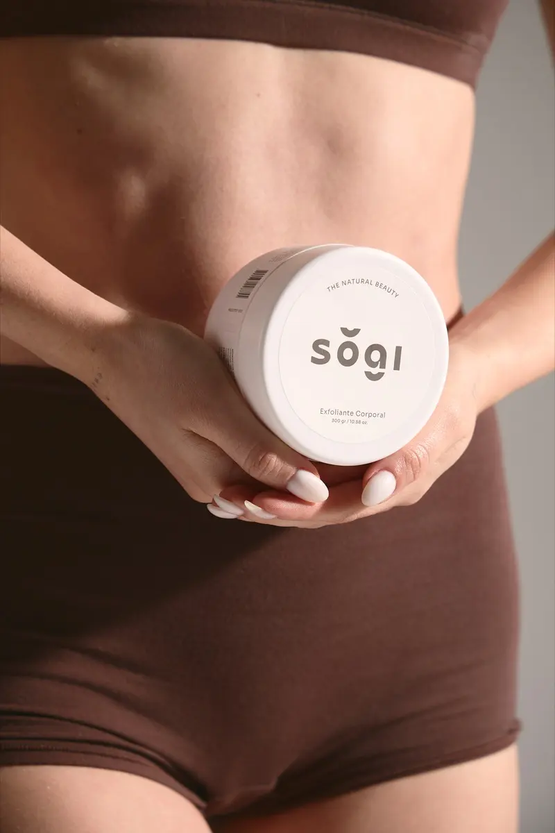 Frasco de exfoliante corporal sŏgi sostenido frente al cuerpo.